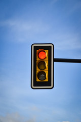 traffic light with sky background with clouds, in red phase