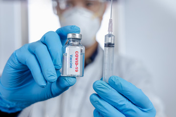 Healthcare cure concept. a doctor hold vaccine on hand in blue medical gloves. during Coronavirus crisis, Covid 19 virus.