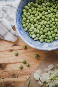 Bol de petits pois crus sur une table en bois
