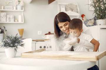 Family in a kitchen. Beautiful mother with little son. Flour at the table