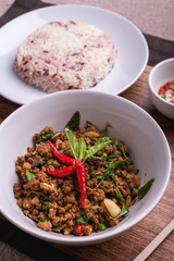 Stir fried minced pork with basil served with steamed jasmin rice and Riceberry, Pad kra pao.