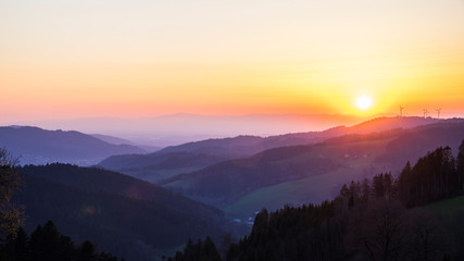 Germany, Romantic orange sunset sky over mountains silhouette in nature landscape of black forest scenery with view from lindenberg mountain