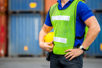 Close up of Engineer, worker man holding hard hat at cargo containers