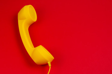 Yellow handset on red background.