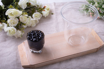 Emty plastic cups for bubble tea on a wooden plate.