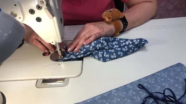 A Woman Sews A Mask From A Fabric With A Blue Print