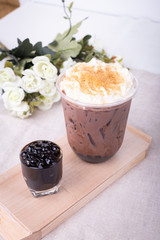 bubble tea in plastic cups on a wooden plate.