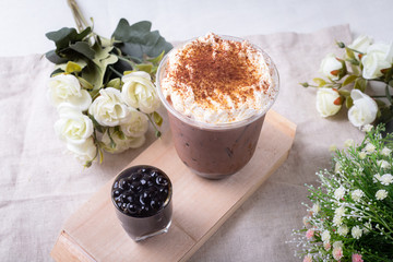 bubble tea in plastic cups on a wooden plate.