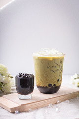 bubble tea in plastic cups on a wooden plate.