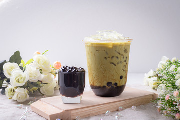 bubble tea in plastic cups on a wooden plate.