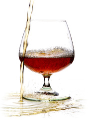 a glass past which pours alcohol, whiskey, brandy on a white isolated background