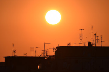 sunset over the roofs of the outskirts of Rome with the many television antennas