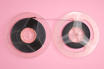 Two movie film reels isolated on pink background top view