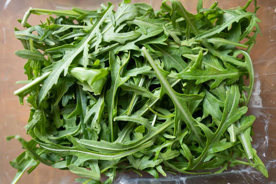 Rucola laying on table, flatlay shot from above, brown kitchen table