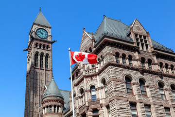 The waving Canadian flag at Old City Hall in background in Toronto, Canada. Toronto is the...