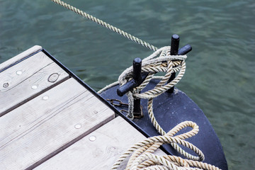 Obraz premium Ship line moored to the mooring post on a modern wooden jetty hobby safety pile group risk of tripping pier expert knowledge