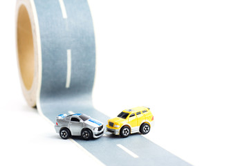 Cars accident on rough road. Two toy models on duct tape. Slippery or rough road.