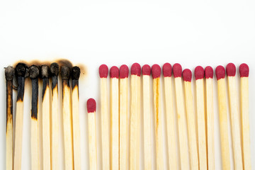 Burnt matches and whole matches on white background. One whole match isolated to stop the fire for...