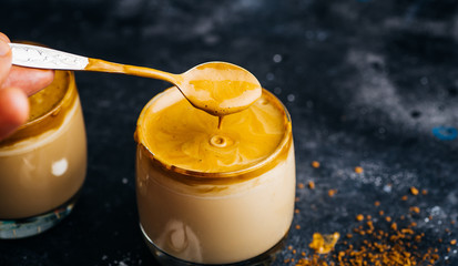 Dalgona coffee drink background. Korean coffee drink made with whipped instant coffee, sugar and milk.