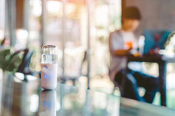 Alcohol nano mist sprayer for hand cleaning to prevent the spread of the corona virus (Covid-19) placed on the table to serve customers before buying in the coffee shop. Modern health technology.