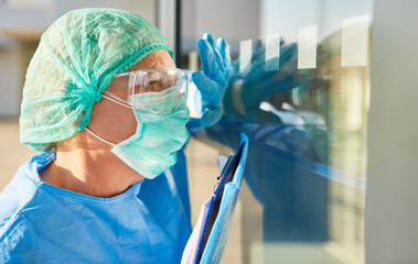 Nursing staff or containment scout with list for contact tracking gives a hand signal