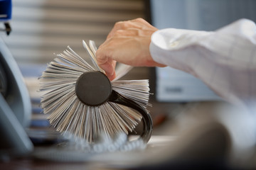 Cropped hand of businessman searching business card in rotary file at office