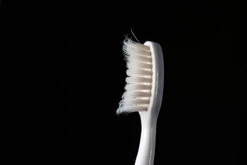 Fototapeta na wymiar Well used toothbrush head close up macro shot isolated on black