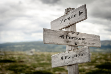 people purpose passion text engraved on wooden signpost outdoors in nature.