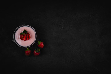 Strawberry pudding on dark background. Top view. Copy space for text message.