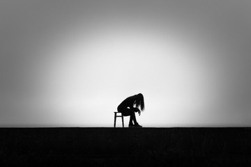 Fototapeta premium A lonely girl looks out into the distance in the rain. Black and white. Loneliness