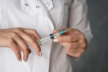 syringe in the hands of a nurse in a white coat