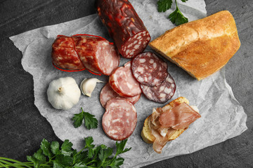 Different types of sausages and bread on black table, flat lay