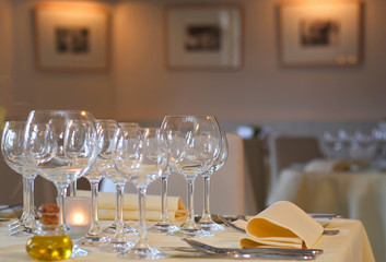 Set dining table in luxury restaurant showing silverware, wine and water glasses and napkins