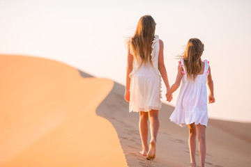 Girls among dunes in Rub al-Khali desert in United Arab Emirates
