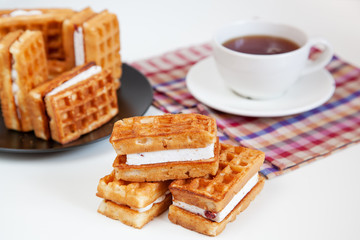 Belgian waffles and tea in a mug on the table.