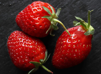 Photography of three strawberries on slate for food background