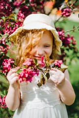 portrait of a little red-haired girl in Apple trees - 350279559