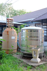 Old fiber water tank and metal water tank at building out door.