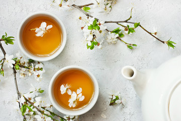 Tea mugs and  cherry  flowers in oriental style, top view