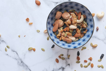 Top view of a bowl of mixed nut in tiles background 