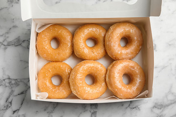 Delicious donuts on marble table, top view