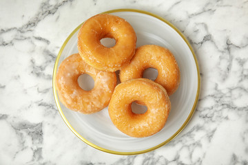 Delicious donuts on marble table, top view