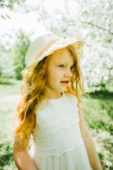 portrait of a little red-haired girl in Apple trees