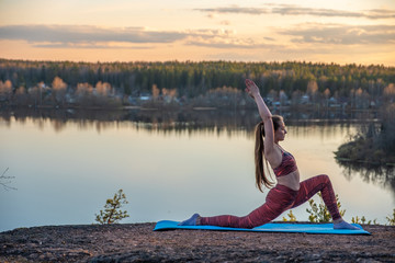 Girl on a rug in the forest does yoga