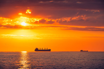 Fototapeta na wymiar Cargo ship with containers in sunrise light