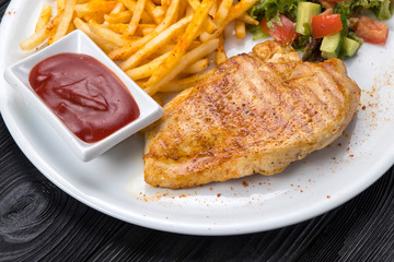 chicken, french fries, sauce on a white plate