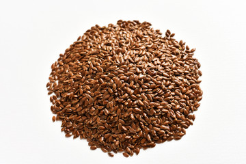 A pile of brown flax or flaxseed on a white background. View from above.