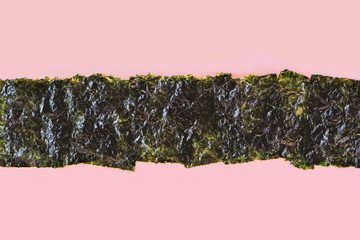 Crispy seaweed on the pink background with copy space. Japanese or korean roasted food texture. Dry nori sheets. Flat lay, top view. © Ekaterina Pavlova