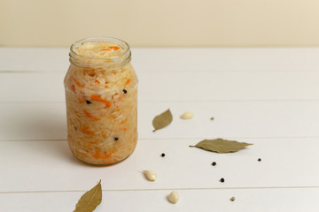 Fermented cabbage with carrots with spices on a white background. Copy space. Selective focus