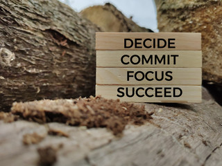 Inspirational and motivational words of decide commit focus succeed on wooden blocks